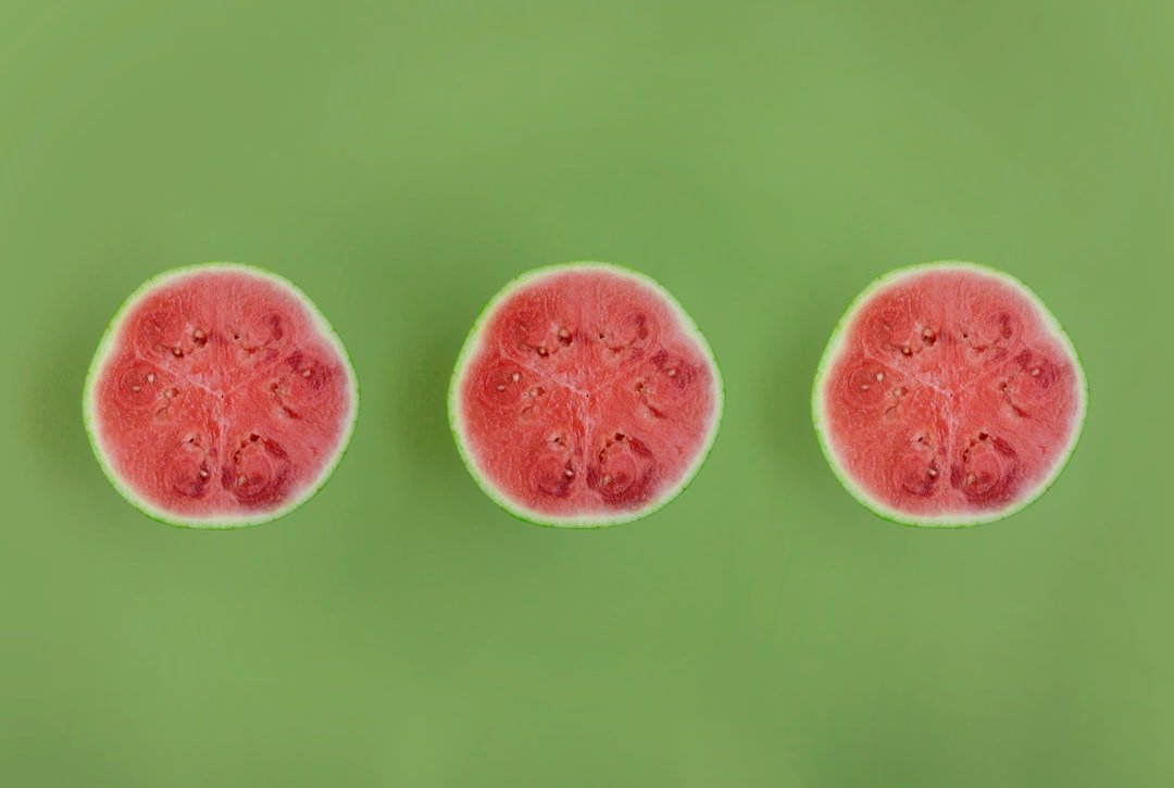 Handful of tiny mouse melons showing their miniature watermelon-striped pattern against green vine leaves